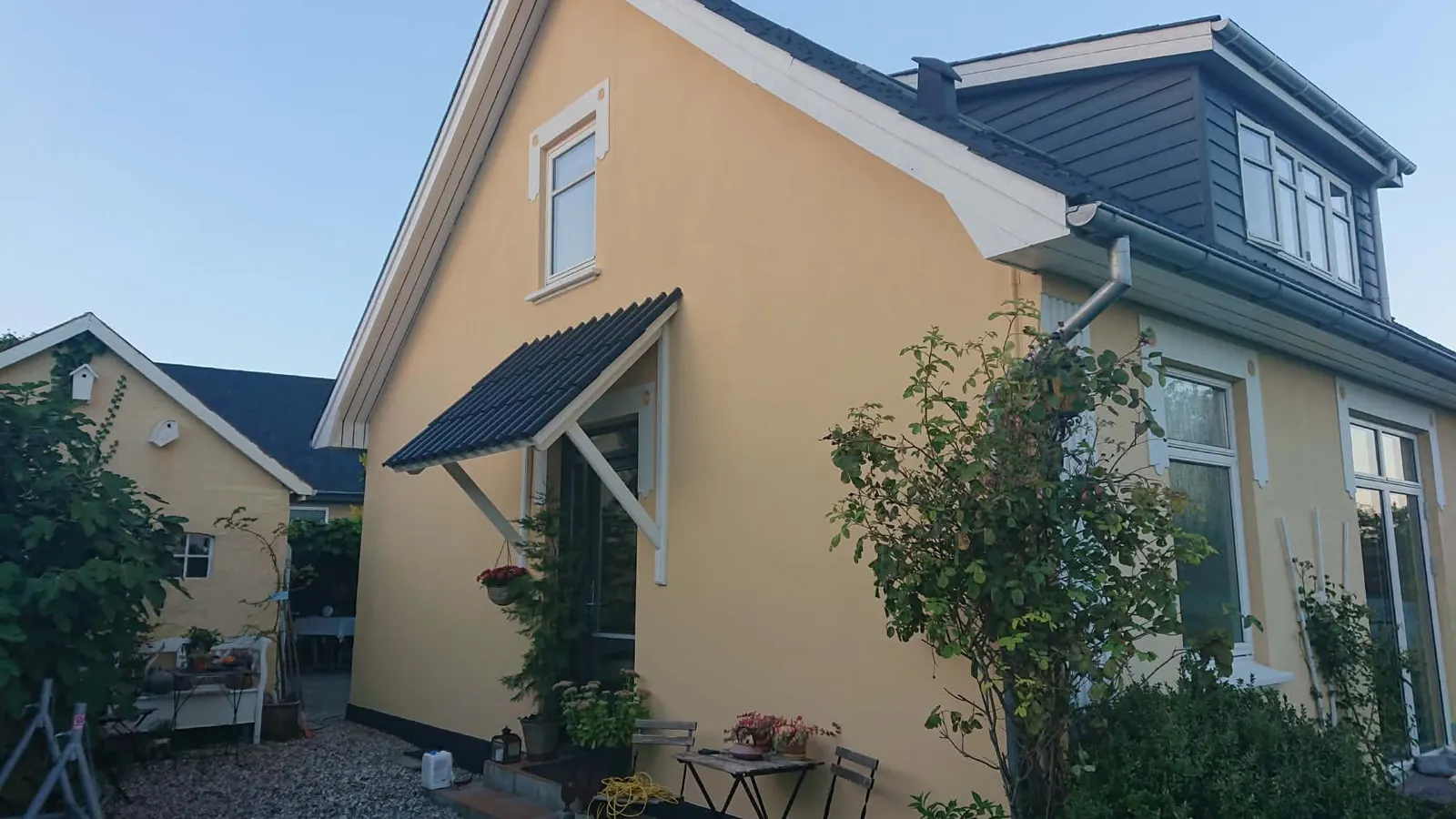 Gulmalet hus med nymalede facader og trædetaljer